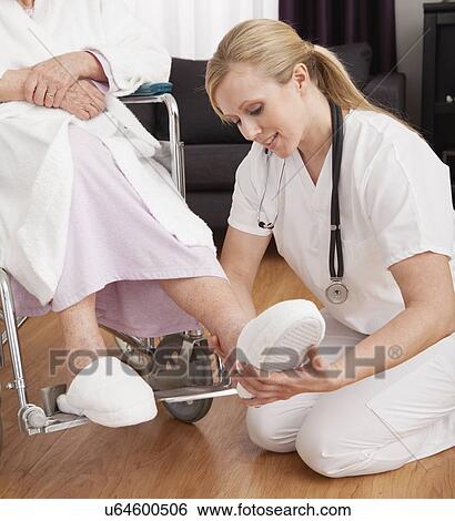 Stock Photograph - Nurse helping senior woman. Fotosearch