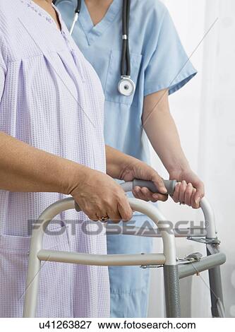 Nurse helping senior woman with walker, close-up View Large Photo Image Stock Photo - Nurse helping senior woman with walker, close-up. Fotosearch