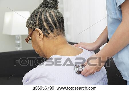 Nurse using stethoscope on female patient's back View Large Photo Image Stock Photo - Nurse using stethoscope on female patient's back. Fotosearch