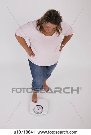 Overweight woman standing on scales View Large Photo Image Stock Image - Overweight woman standing on scales. Fotosearch