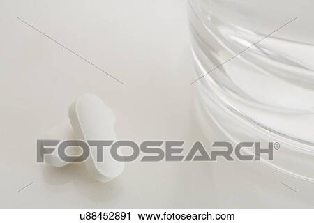 Stock Image - Painkiller and glass of water. Fotosearch