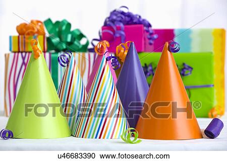 Stock Image - Party hats, gifts in background, close-up. Fotosearch