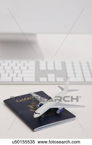 Passport, model airplane and computer on desk View Large Photo Image Stock Photography - Passport, model airplane and computer on desk. Fotosearch