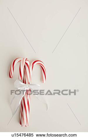 Stock Photography - Peppermint candy canes tied with white ribbon on white background. Fotosearch