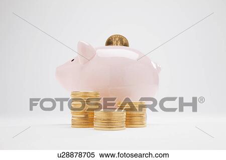 Stock Photography - Piggybank with gold coins in stack, studio shot. Fotosearch