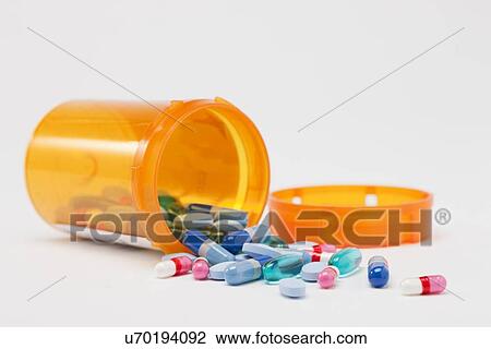 Stock Image - Pills and prescription bottle, studio shot. Fotosearch