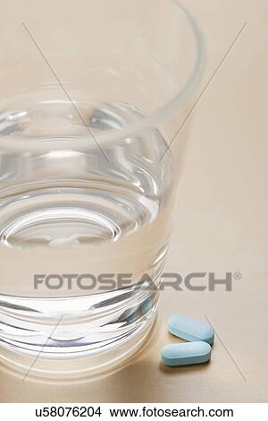 Pills near glass with water, studio shot View Large Photo Image Picture - Pills near glass with water, studio shot. Fotosearch