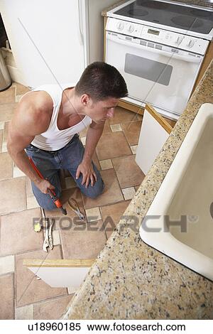Plumber fixing kitchen sink View Large Photo Image Stock Photography - Plumber fixing kitchen sink. Fotosearch
