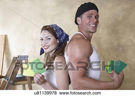 Stock Photo - Portrait of couple holding color samples. Fotosearch