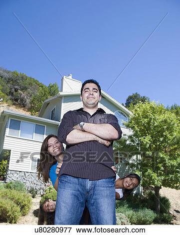 Portrait of family with two girls (8-9, 14-15) in front of house View Large Photo Image Stock Photo - Portrait of family with two girls (8-9, 14-15) in front of house. Fotosearch