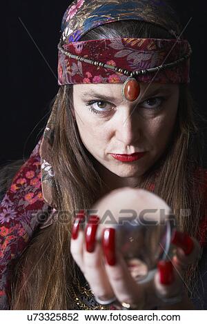 Stock Image - Portrait of fortune teller holding crystal ball. Fotosearch