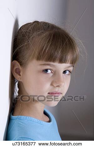 Portrait of girl (8-9) leaning against wall View Large Photo Image Stock Photo - Portrait of girl (8-9) leaning against wall. Fotosearch