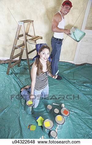 Portrait of happy couple painting room View Large Photo Image Stock Photo - Portrait of happy couple painting room. Fotosearch