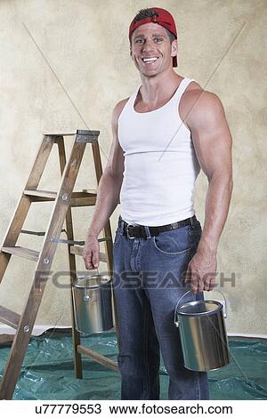 Portrait of man holding paint cans in drop cloth covered room View Large Photo Image Stock Image - Portrait of man holding paint cans in drop cloth covered room. Fotosearch