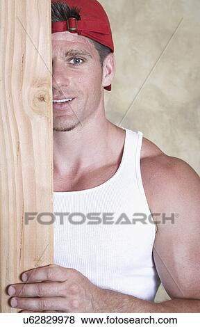 Portrait of man holding piece of wood View Large Photo Image Stock Photo - Portrait of man holding piece of wood. Fotosearch