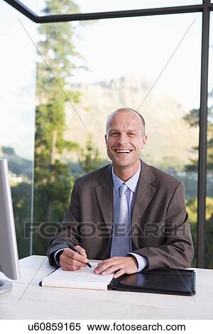 Portrait of mid adult businessman signing document, smiling View Large Photo Image Stock Photography - Portrait of mid adult businessman signing document, smiling. Fotosearch