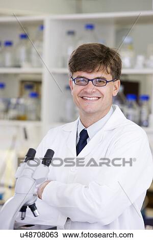 Stock Image - Portrait of mid adult scientist. Fotosearch