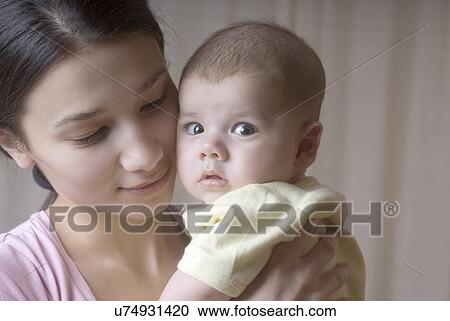 Portrait of mother holding baby (6-11 months) View Large Photo Image Stock Image - Portrait of mother holding baby (6-11 months). Fotosearch