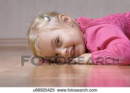 Portrait of smiling girl (4-5) lying on floor View Large Photo Image Stock Photography - Portrait of smiling girl (4-5) lying on floor. Fotosearch