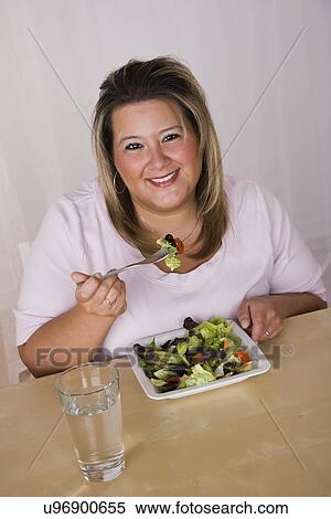 Portrait of smiling young woman eating salad View Large Photo Image Stock Photography - Portrait of smiling young woman eating salad. Fotosearch