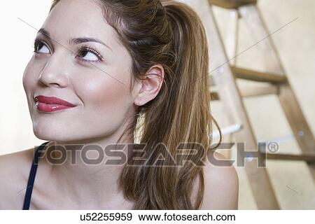 Portrait of smiling young woman, ladder in background View Large Photo Image Stock Photo - Portrait of smiling young woman, ladder in background. Fotosearch