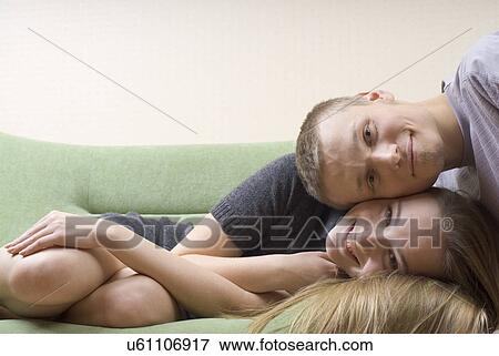Portrait of young couple relaxing on sofa View Large Photo Image Stock Photo - Portrait of young couple relaxing on sofa. Fotosearch