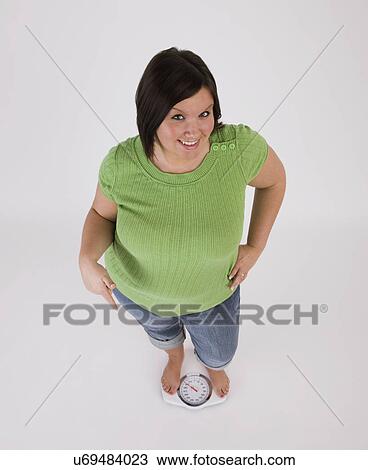 Portrait of young overweight woman standing on scales View Large Photo Image Stock Image - Portrait of young overweight woman standing on scales. Fotosearch