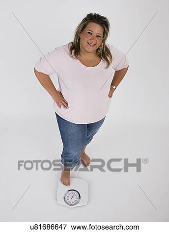 Portrait of young overweight woman standing on scales View Large Photo Image Stock Photo - Portrait of young overweight woman standing on scales. Fotosearch
