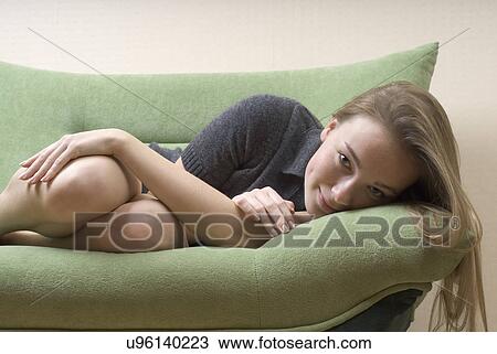 Portrait of young woman relaxing on sofa View Large Photo Image Stock Image - Portrait of young woman relaxing on sofa. Fotosearch