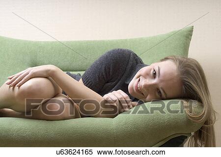 Portrait of young woman relaxing on sofa View Large Photo Image Stock Photography - Portrait of young woman relaxing on sofa. Fotosearch