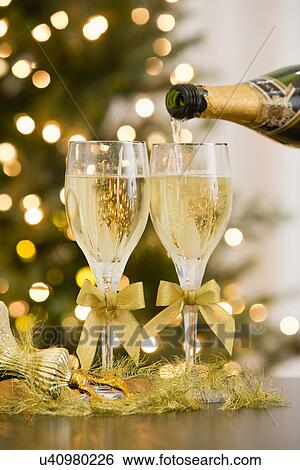 Stock Photograph - Pouring champagne into champagne flutes. Fotosearch