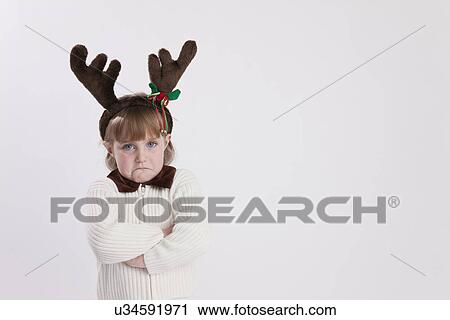 Pouting young girl (4-5) wearing reindeer antler headband, studio shot View Large Photo Image Stock Image - Pouting young girl (4-5) wearing reindeer antler headband, studio shot. Fotosearch