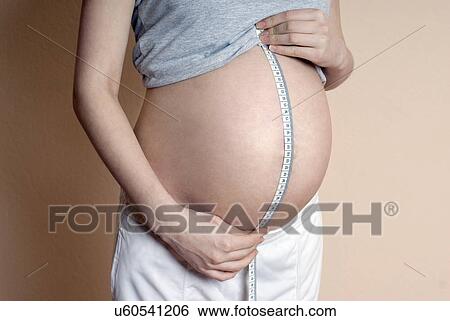 Pregnant woman measuring belly with measure tape, mid section View Large Photo Image Stock Photograph - Pregnant woman measuring belly with measure tape, mid section. Fotosearch