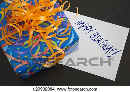 Present with birthday card on black background View Large Photo Image Picture - Present with birthday card on black background. Fotosearch