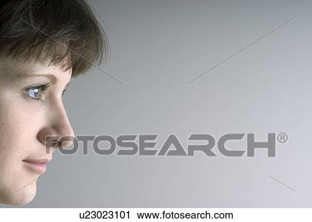 Profile of young woman against white background View Large Photo Image Stock Image - Profile of young woman against white background. Fotosearch