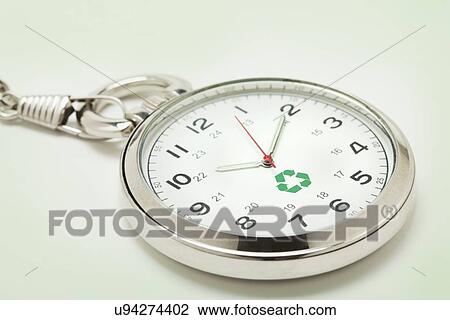 Stock Image - Recycling symbol on pocket watch, studio shot. Fotosearch