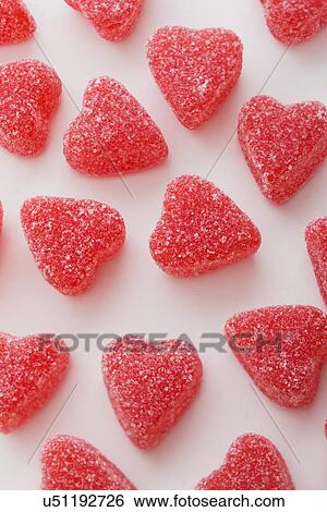 Stock Photograph - Red heart shape candies on white background. Fotosearch