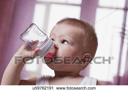 Stock Image - Russia, Voronezh, baby boy (12-17 months) drinking from baby bottle. Fotosearch