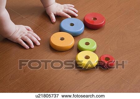 Stock Photo - Russia, Voronezh, baby boy (12-17 months) playing with colorful rings. Fotosearch