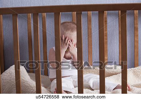 Stock Photo - Russia, Voronezh, baby boy (12-17 months) crying in crib. Fotosearch