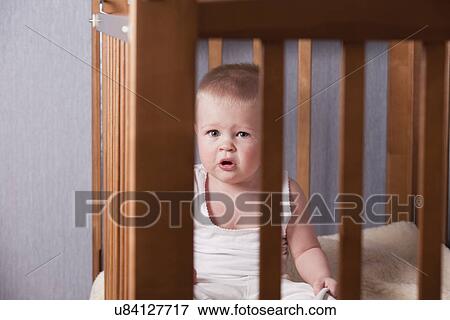 Stock Photo - Russia, Voronezh, baby boy (12-17 months) crying in crib. Fotosearch