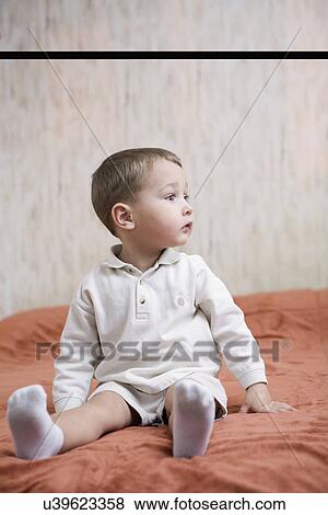 Stock Photo - Russia, Voronezh, Boy (2-3) sitting on bed. Fotosearch