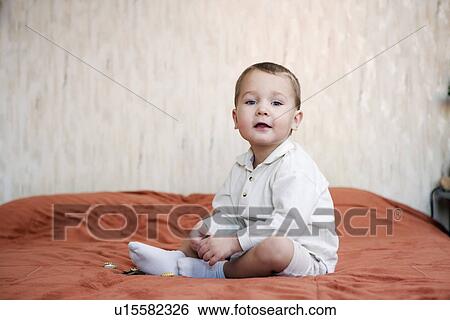Russia, Voronezh, Boy (2-3) sitting on bed View Large Photo Image Stock Photograph - Russia, Voronezh, Boy (2-3) sitting on bed. Fotosearch
