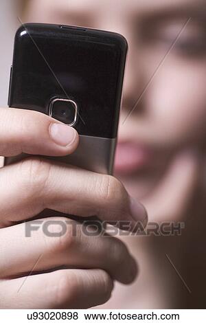 Stock Photo - Russia, Voronezh, Close-up of teenage girl's (12-13) hand holding mobile phone. Fotosearch