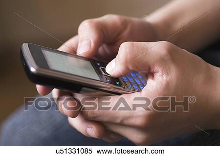 Stock Photography - Russia, Voronezh, Close-up of teenage girl's (12-13) hands holding mobile phone. Fotosearch