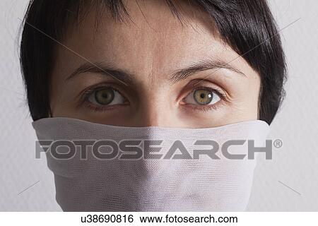 Stock Photograph - Russia, Voronezh, close-up of woman wearing gauze covering mouth. Fotosearch