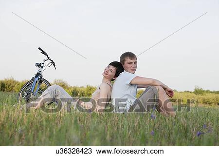 Russia, Voronezh, couple sitting in meadow View Large Photo Image Stock Image - Russia, Voronezh, couple sitting in meadow. Fotosearch