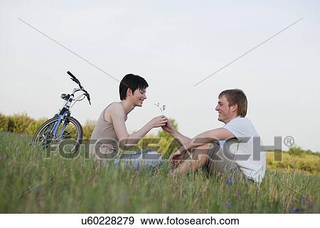 Stock Photo - Russia, Voronezh, couple sitting in meadow. Fotosearch
