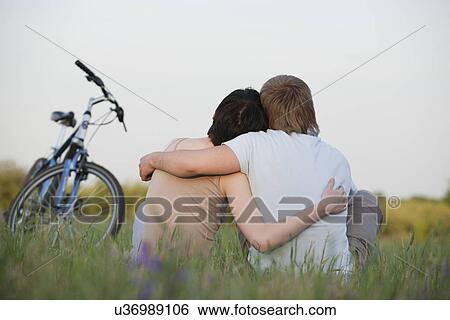 Russia, Voronezh, couple sitting in meadow View Large Photo Image Stock Photograph - Russia, Voronezh, couple sitting in meadow. Fotosearch