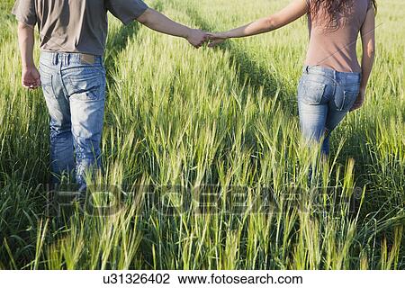 Russia, Voronezh, couple walking through field View Large Photo Image Stock Image - Russia, Voronezh, couple walking through field. Fotosearch